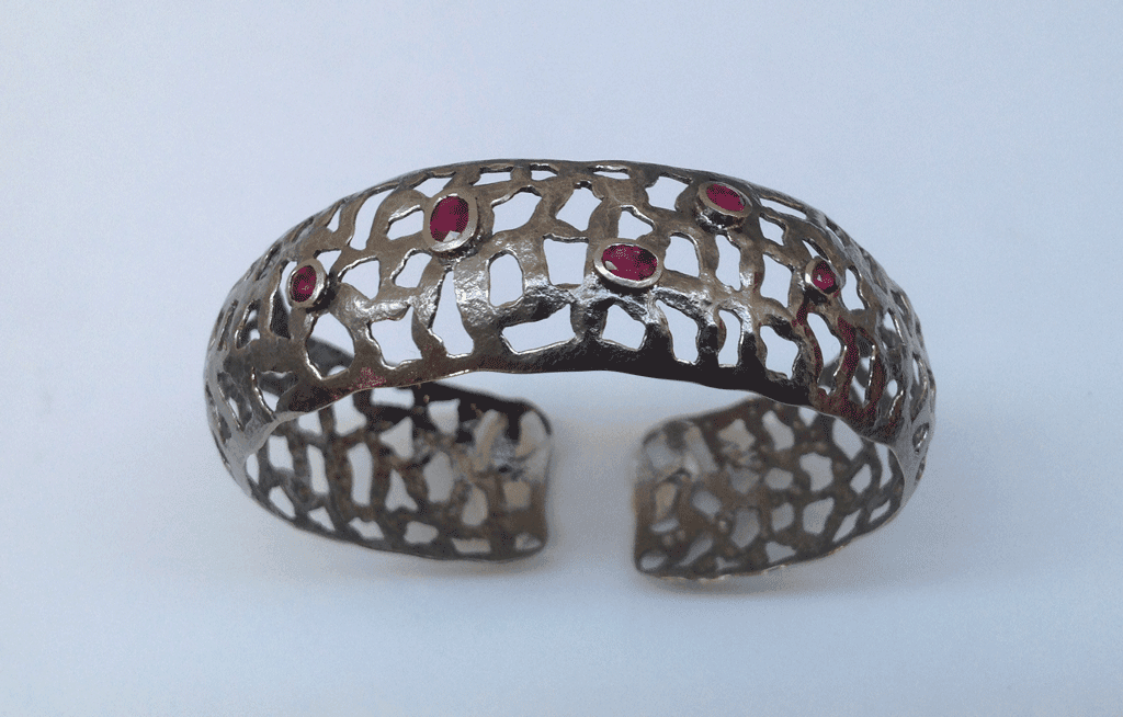 18 carat white gold bangle, black rhodium plated, rubies