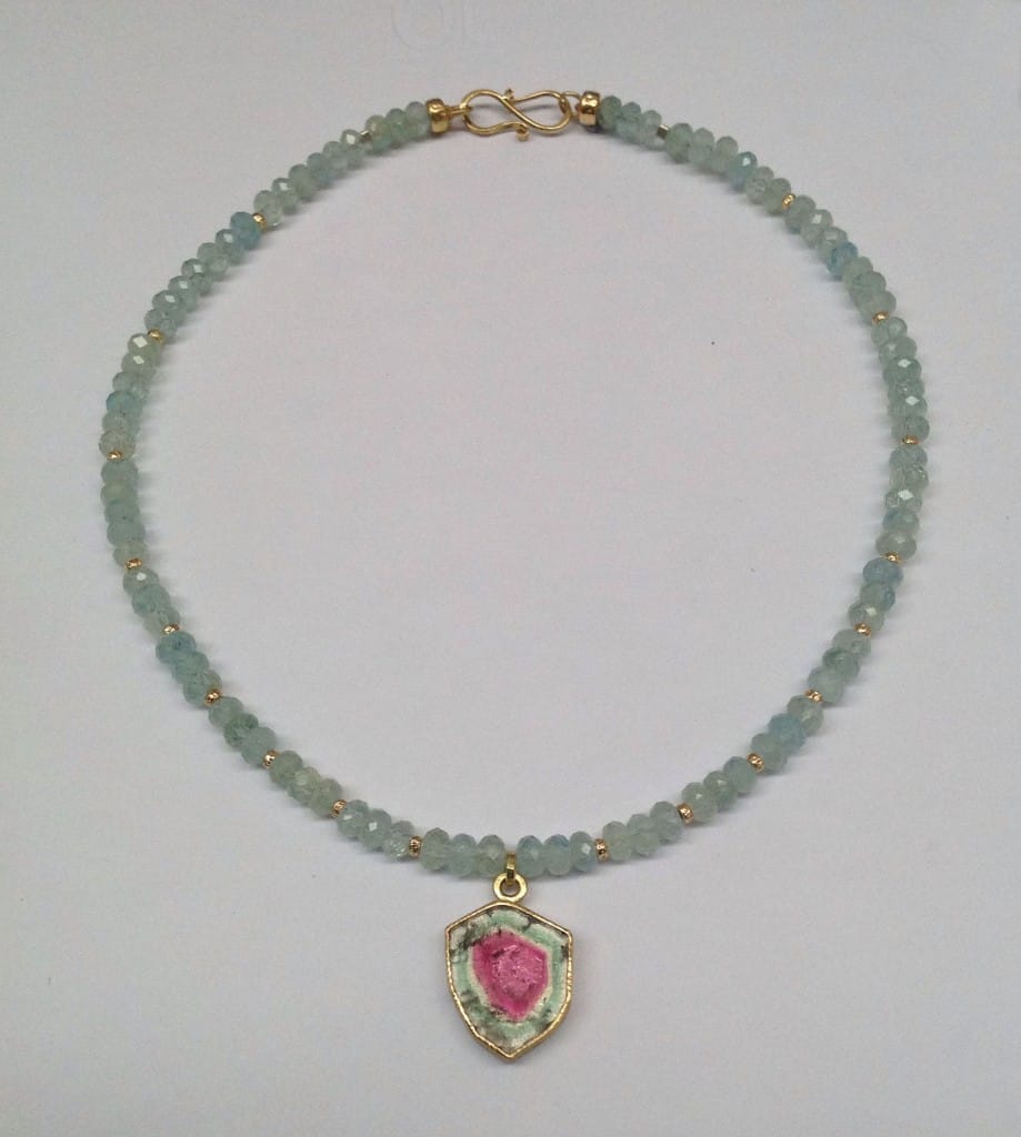 Watermelon tourmaline set in 18 carat yellow gold, faceted aquamarine beads