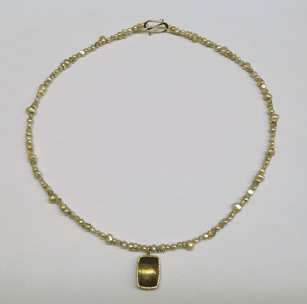 Yellow tourmaline set in 18 carat green gold, peridot beads, green pearls and 18 carat yellow gold beads