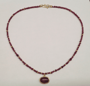 Opaque ruby set in 18 carat yellow gold, ruby, garnet and 18 carat yellow god beads