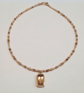 Faceted peach tourmaline set in 18 carat yellow gold, tourmaline beads and cream pearls