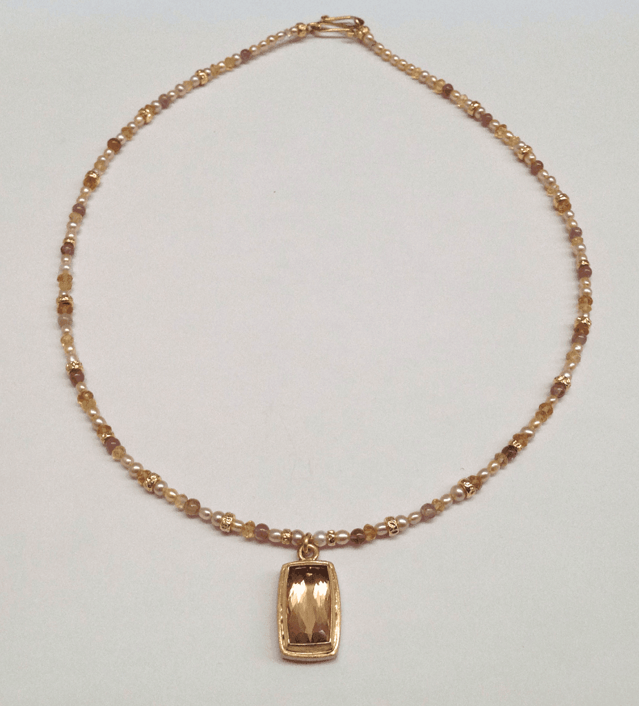 Faceted peach tourmaline set in 18 carat yellow gold, tourmaline beads and cream pearls