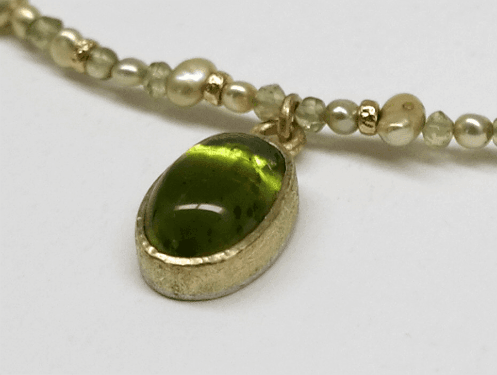 Detail of Peridot set in 18 carat yellow gold, peridot beads, freshwater pearls