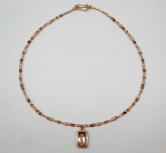 Faceted peach tourmaline set in 18 carat yellow gold, tourmaline beads and cream pearls