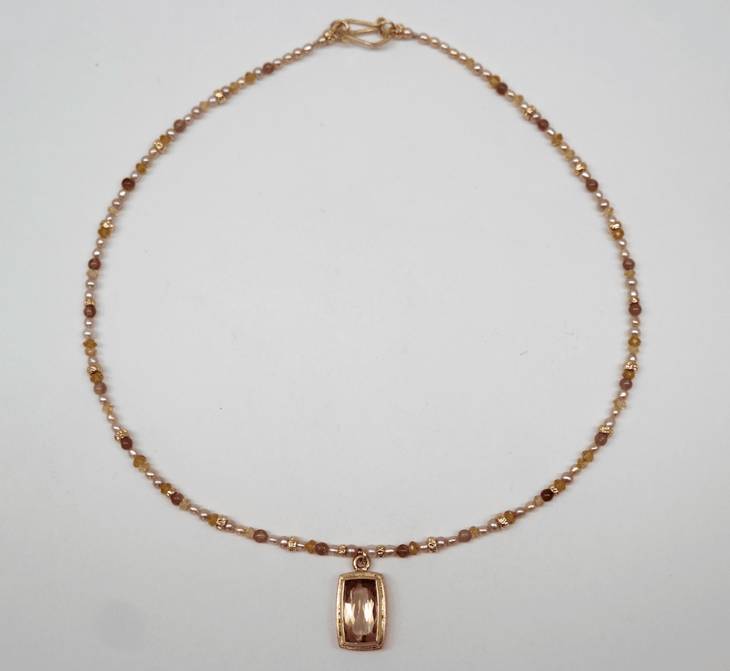 Faceted peach tourmaline set in 18 carat yellow gold, tourmaline beads and cream pearls